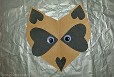 a paper mask with eyes and hearts on it