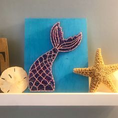 two starfishs and one seahorse on a shelf