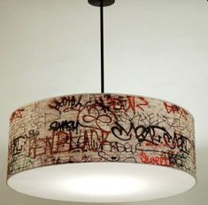 a chandelier with graffiti on it hanging from a ceiling fixture in a room