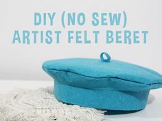 a blue hat sitting on top of a white table next to a piece of cloth