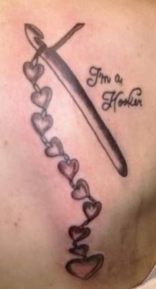 a woman's chest with a knife and hearts on it that says i'm a mother