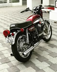 a red motorcycle parked on top of a tiled floor