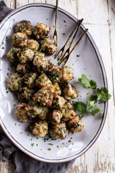 a white plate topped with meatballs and garnished with parsley