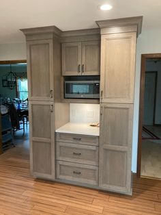 an empty kitchen with wooden floors and cabinets