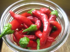 some red peppers are in a glass bowl