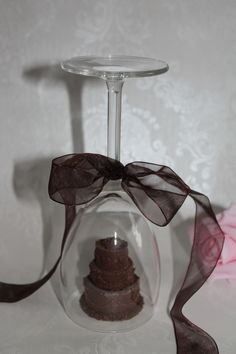 a cake in a wine glass with a ribbon around it