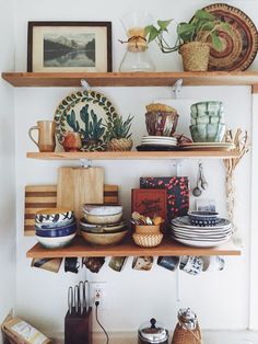 the shelves are filled with plates, bowls and utensils