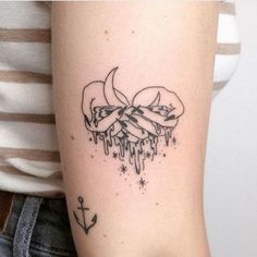 a woman's arm with a tattoo on it that has an arrow and flowers