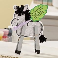 a toy horse is sitting on top of a desk next to some pens and markers