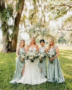 the bride and her bridesmaids pose for a photo in front of a tree