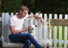 a man sitting on a bench with his dog