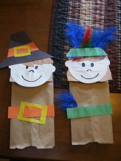 two paper bag puppets with faces on them