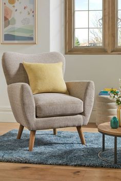 a living room with a gray chair and yellow pillows