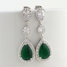 Luxury green emerald cubic zirconia bridal teardrop earrings in rhodium plated brass setting. Earrings feature a large teardrop with pear cut green emerald cubic zirconia center surrounded by tiny round zirconia crystals. Teardrop dangles from a clear cubic zirconia ear stud and a round cubic zirconia connector. Total length of the earring is 4.6 cms. Also available in clip on style. For matching necklace click: https://www.etsy.com/listing/481705468/green-emerald-cubic-zirconia-bridal?ref=listi Green Teardrop Wedding Earrings, Green Teardrop Dangle Earrings For Wedding, Green Teardrop Earrings For Wedding, Green Teardrop Bridal Earrings For Wedding, Cubic Zirconia Teardrop Earrings For May Birthstone, Pear-shaped Emerald Earrings For Wedding, May Birthstone Teardrop Cubic Zirconia Earrings, Silver Emerald Bridal Earrings For Wedding, Wedding Drop Earrings With Emerald