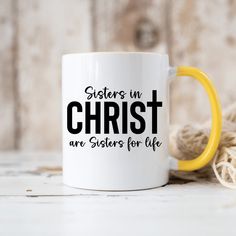 a yellow and white coffee mug with the words sisters in christ are sisters for life