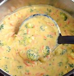 broccoli and carrots are being stirred in a pot with a ladle