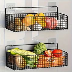 two metal baskets filled with fruits and vegetables on top of a white tiled wall next to each other