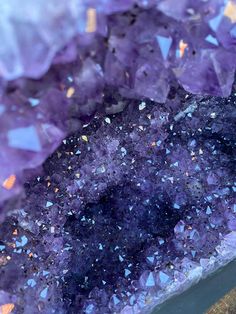 purple crystals with gold flecks on them are shown in this close up photo