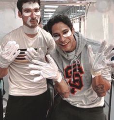 two men wearing white gloves and face paint