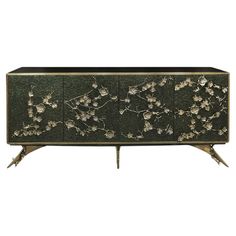 a black and gold sideboard with flowers on the front, two legs and three doors