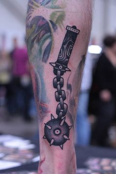 a man with a tattoo on his leg has a knife and chain attached to it