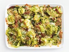 a casserole dish with broccoli, cheese and other toppings on it