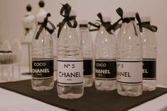 six chanel water bottles with black bows on them