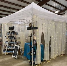 a white tent with curtains and lights on the side is set up for an event