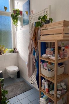 a bathroom with a shelf filled with toiletries next to a window