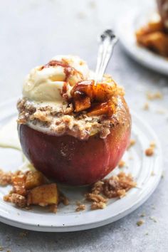 an apple dessert with ice cream and nuts on a white plate, ready to be eaten