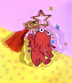 an octopus keychain with a star on the top and a tassel hanging from it