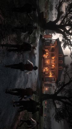 a group of people standing next to each other in front of a building at night