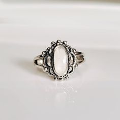 Colors Vary Due To The Nature Of The Stone Design: Vintage, Art Deco, Beaded Top Of Ring Height: 12.8mm X 11.5mm Band Width: 1.9mm Center Stone Size: 9.3mm X 4.6mm Stone Shape: Oval Genuine Mother Of Pearl Total Number Of Stones: 1 Metal: 925 Sterling Silver Finish: Oxidized 925 Stamped K E E P I N T O U Ch Https://Instagram.Com/Emmaverajewelry Https://Www.Facebook.Com/Emmaveradesign Thank You For Visiting My Shop White Classic Adjustable Midi Rings, White Sterling Silver Crystal Open Ring, White Sterling Silver Open Crystal Ring, Classic White Cabochon Moonstone Ring, White Moonstone Ring For Promise, Bohemian White Nickel-free Ring, White Oval Bohemian Ring, Bohemian White Oval Rings, Bohemian White Oval Ring