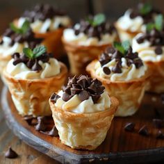 mini desserts with chocolate chips and cream on a wooden platter, ready to be eaten