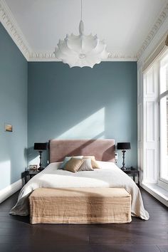 a bed room with a neatly made bed and purple wall decals on the walls