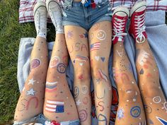 four people with painted legs laying on the ground in front of them are wearing american flags and stars