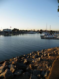 boats are docked in the water near rocks