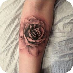 a black and white rose tattoo on the arm