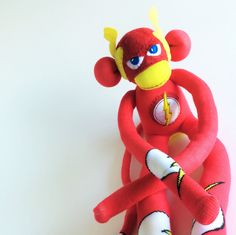 a red stuffed animal sitting on top of a white table next to a yellow object