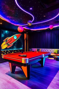 a pool table with a rocket ship painted on the wall next to it and couches