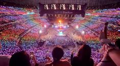 a crowd of people at a concert with their cell phones in the air and lights on