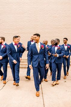 a group of men in suits walking down a sidewalk