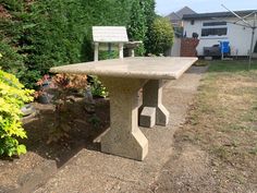 a concrete table sitting in the middle of a yard