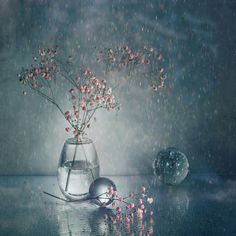 a vase filled with flowers sitting on top of a table next to a glass ball