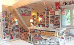 a room filled with lots of toys and books on shelves next to a desk in front of a window