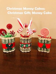 three candy canes wrapped in dollar bills are sitting on a table next to each other