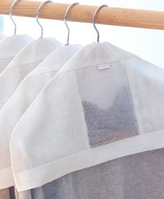 three bags are hanging on a rack with some cloths attached to the hangers