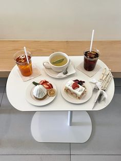 a table topped with plates and cups filled with food on top of a white plate