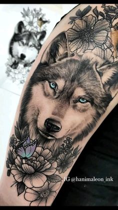 a wolf with blue eyes and flowers on his arm is shown in black and grey