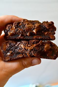 two chocolate brownies are being held in front of the camera